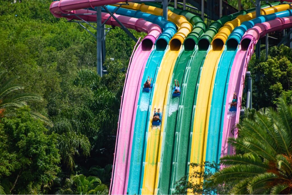 Multi lane water slides with people racing down.