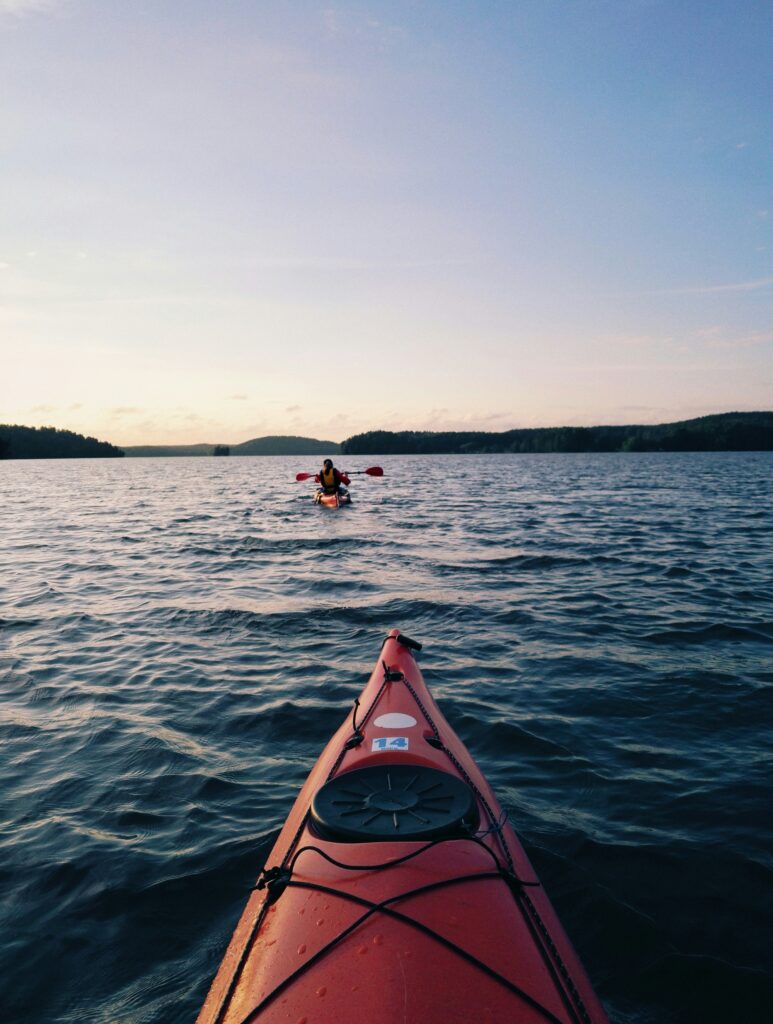 Kayak floating on calm water during sunset.