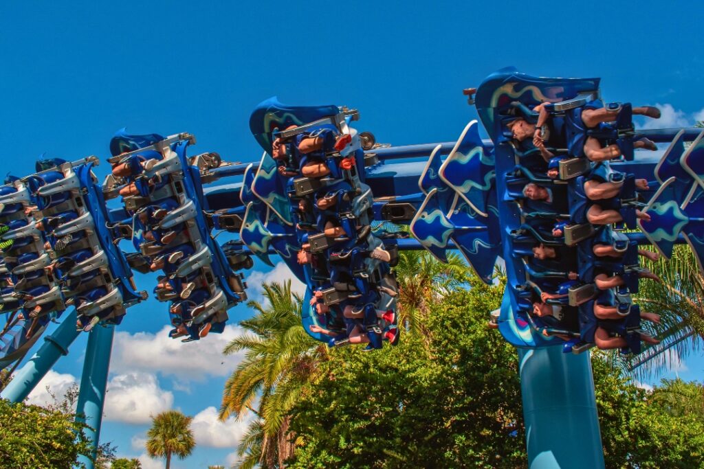 People riding an inverted roller coaster at an amusement park.